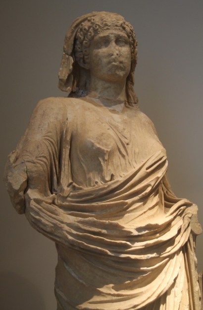 Statue d'Agrippine la jeune portant une tunique et une coiffe sur ses cheveux bouclés