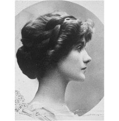 Portrait de Coco Chanel dans sa jeunesse. De profil, elle regarde vers la droite et ses cheveux bruns sont retenus dans un chignon élaboré.