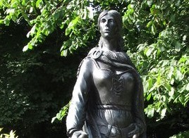 Photographie d'une statue représentant Grace O'Malley. Elle est représentée portant une cape et une robe lacée sur la poitrine.