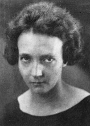 Photographie en noir et blanc d'Irène Joliot-Curie montrant son visage de face. La photo date d'environ 1935, Irène Joliot-Curie est âgée d'environ 38 ans.