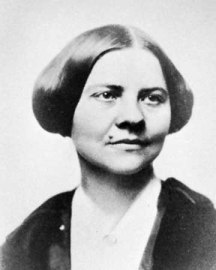 Photographie en noir et blanc de Lucy Stone. Ses cheveux sombres sont coupés court.