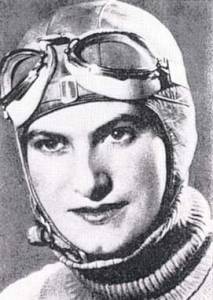 Photographie en noir et blanc d'Hélène Boucher montrant son visage. Elle porte une cagoule et des lunettes d'aviatrice sur le front.