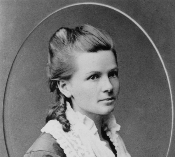 Cette photographie en noir et blanc est un portrait de Bertha Benz dans un cadre ovale. La jeune fille porte une veste sombre avec un large col blanc de dentelle ; ses cheveux sont coiffés en mèches anglaises.