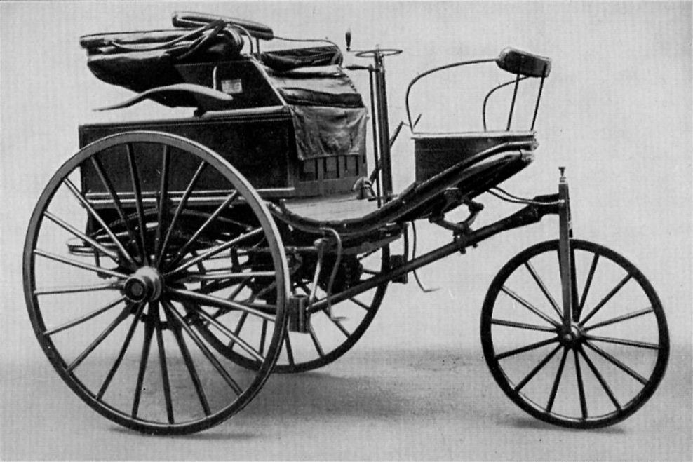 Cette photographie en noir montre le tricycle Benz 3, modèle utilisé par Bertha Benz lors de son voyage. Le véhicule possède une roue directrice à l'avant et  deux plus grandes roues à l'arrière, surmontées par le siège du conducteur.
