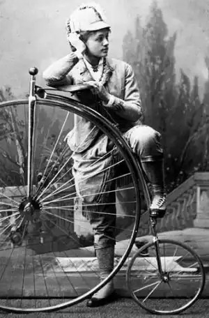 Cette photographie en noir et blanc montre la cycliste Elsa von Blumen debout devant son grand bi.